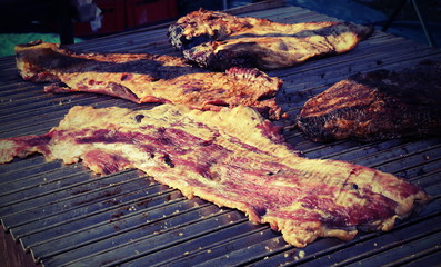 grilled meat in a food stall on the street with bacon and cooked