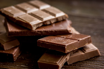 black and milk chocolate bars dark wooden table background