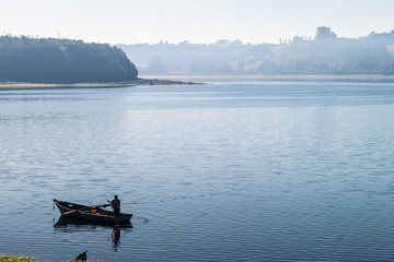 CASTRO, CHILE - MARCH 23, 2015: Fisherman in a morning mist on a sea in Castro, Chiloe island, Chile