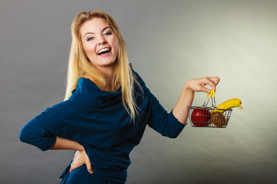 Woman holding shopping basket with fruits inside