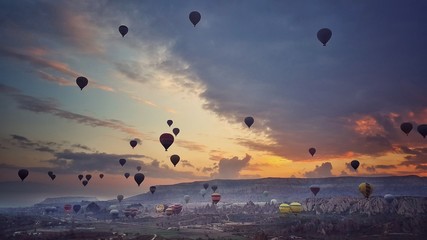 Colorful hot air balloons flying over the valley at Cappadocia, Turkey. Beautiful Sunrise.