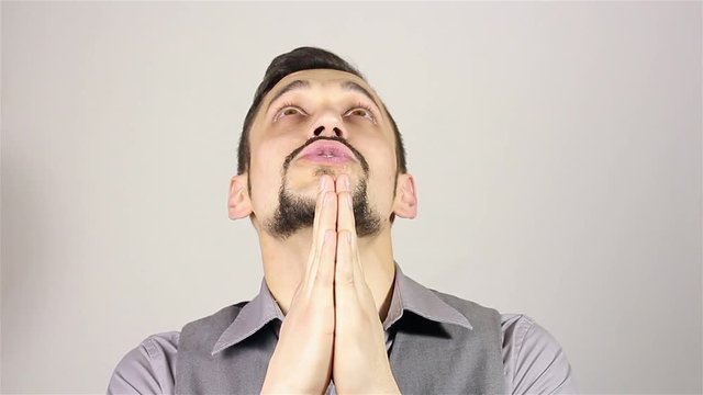 Young bearded man praying, asking God for help.