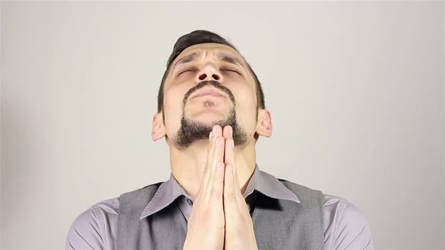 Young bearded man praying, asking God for help.