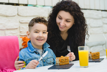 Boy and mother or happy family having healthy breakfast in resort cafe outdoor