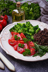 Salad with black quinoa, cherry tomatoes, broccoli and arugula