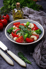 Salad with pasta, tomatoes, broccoli and arugula