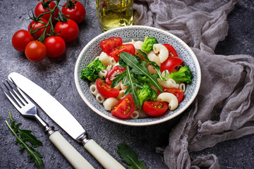 Salad with pasta, tomatoes, broccoli and arugula