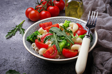 Salad with pasta, tomatoes, broccoli and arugula