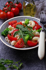 Salad with pasta, tomatoes, broccoli and arugula