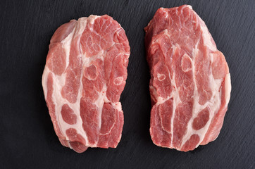 Two fresh raw boneless pork shoulder butt slices