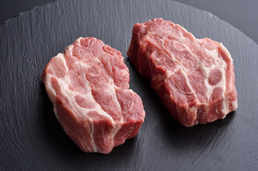 Two fresh raw boneless pork shoulder butt slices