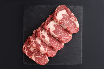 Fresh raw Prime Black Angus beef steaks on stone plate - obrazy, fototapety, plakaty