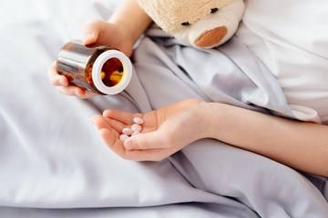 Sick child boy takes medication in bed © Daniel Jędzura