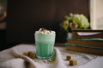Green mint coffee with with cream and colorful decoration on dark background. Milk shake, cocktaill, frappuccino.  Unicorn coffee, unicorn food.