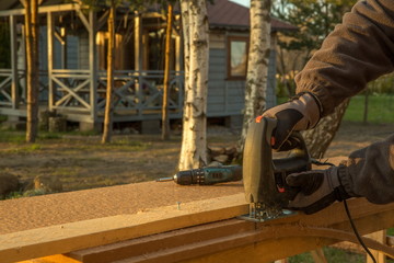 The worker by means of the tool performs work with wood fiber plate insulation