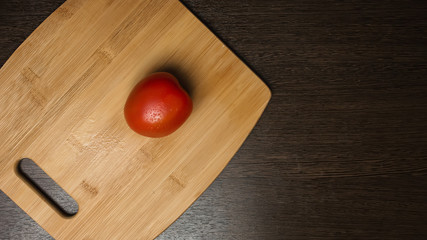 Fresh tomatoes on wooden cutting board