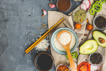 Rice and Food Ingredients over dark rustic background. Vegetarian concept. Asian or Indian food