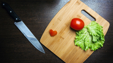 heart-shape tomato on wooden cutting board