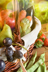 Fruits and vegetables in a wicker basket on table vertical