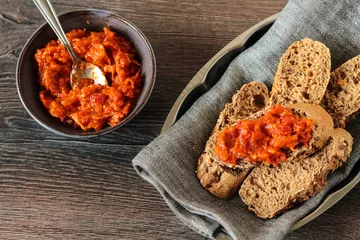 Foto op Plexiglas A bowl of red pepper and walnut dip served with bread © DIA