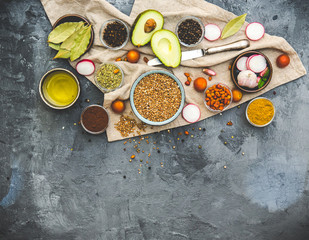 Buckwheat with vegetables, spices and herbs over dark rustic background. Top view, copy space