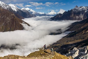 Photo sur Plexiglas Manaslu Trekker sur le chemin de la vallée couverte de nuages sur le trek du circuit du Manaslu au Népal