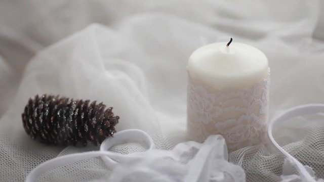 the white candle is lit on a white background