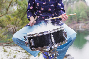 Girl plays the drum outdoors.