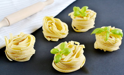 Italian raw homemade pasta tagliatelle. Black background