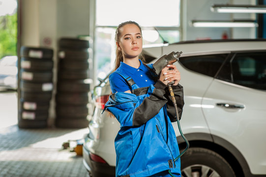 Young beautiful girl at an auto mechanic at work