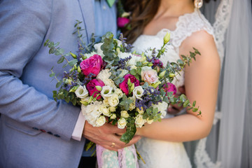 Obraz na płótnie Canvas Newlyweds couple with bouquet of flowers, bride and groom with wedding bouquet