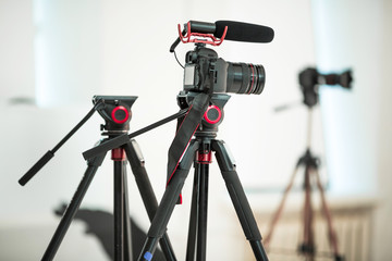 Concept interview, digital camera on a tripod with a microphone in the studio on a white background.