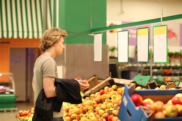 Young man with a shopping cart in a supermarket 
