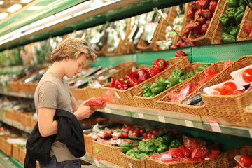 Young man with a shopping cart in a supermarket 