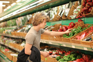 Young man with a shopping cart in a supermarket 