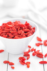 Goji berries in bowl on white background