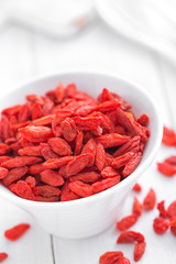 Goji berries in bowl on white background