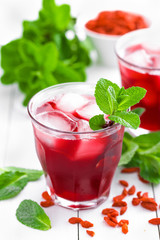 Healthy detox drink with goji berries infused in water with ice, cold refreshing beverage