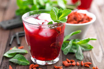 Healthy detox drink with goji berries infused in water with ice, cold refreshing beverage