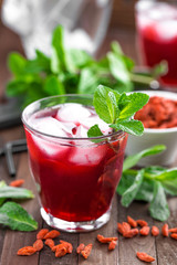Healthy detox drink with goji berries infused in water with ice, cold refreshing beverage
