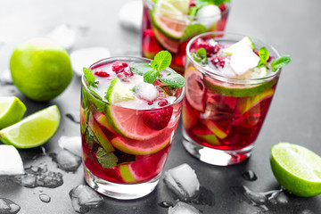Raspberry mojito cocktail with lime, mint and ice, cold, iced refreshing drink or beverage