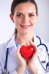 Young woman doctor holding a red heart