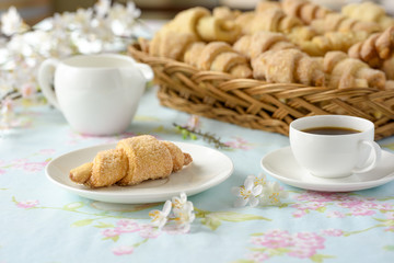 Many croissants on a table with spring flowers
