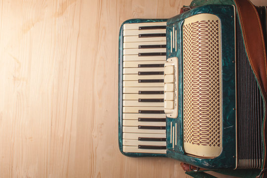 vintage musical accordion on wooden desk close up photo top view, mock up