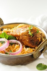 Chicken Biryani on white background served in a traditional Kadai, selective focus