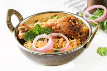 Chicken Biryani on white background served in a traditional Kadai, selective focus