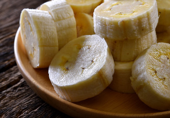 Banana in wooden dish on wood