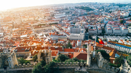 Fototapeta premium Aerial panoramic view over Lisbon in beautiful sunset sunshine.Saint George castle,downtown and neighbourhood of Alfama,river Tagus in european capital,Lisbon,Portugal.Aerial travel photography