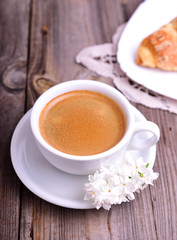 Black coffee in a white cup on a gray wooden surface
