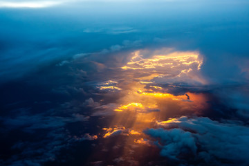 Fototapeta premium Aerial view of a cloudy sunset while flying above the clouds